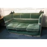 A Knole three-seater sofa with oval shaped finials and drop-down sides, with green upholstery and