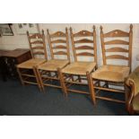 A set of four rush seated ladderback dining chairs with turned finials