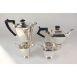 A George V silver three-piece tea set, square Art Deco form on circular pedestal feet with chevron