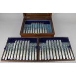 A cased set of eighteen dessert knives and sixteen dessert forks, with mother of pearl handles, in