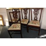 A set of four Chippendale style mahogany dining chairs with pierced ribbon splats, drop-in