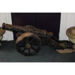 A cast iron model of a cannon with 100cm barrel cast with an armorial, on frame with wheels, 148cm
