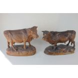 Two carved wooden models of a bull and a cow, 22cm high, (a/f)