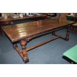 An oak refectory table, rectangular three-plank top with dowelled breadboard ends, on block and