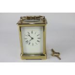 A brass carriage clock with bell striking mechanism, white dial with Roman numerals, 17.5cm high