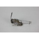 A Chinese white metal miniature model of a sedan chair with filigree design, initialled SF, with