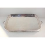 A silver plated two-handled serving tray, rounded rectangular form with pierced sides, raised on