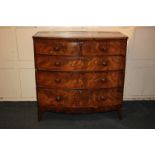 A bow front mahogany chest of two short over three long drawers, with cross banded top, on curved