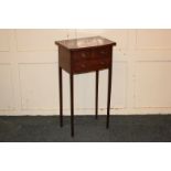 A small mahogany side table with rectangular shaped top and an arrangement of three drawers, on