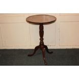 An Edwardian mahogany wine table, circular top with central inlaid paterae, on carved baluster