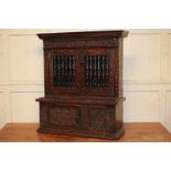 A 17th century carved oak mural livery cupboard with moulded and dentil carved cornice, scroll