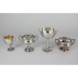 Four various 20th century small silver trophy cups, including one with handles in the form of golf