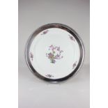 A Lenox porcelain charger with silver plated mount, decorated with pink blossom branches and