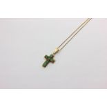 An emerald cross pendant, claw set with six mixed cut stones in yellow gold on an 18ct gold box link