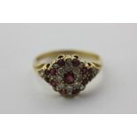 A ruby and diamond cluster ring set with rose cut and circular cut stones