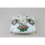 A Meissen porcelain cushion inkwell with bocage floral design and gilt embellishment, crossed