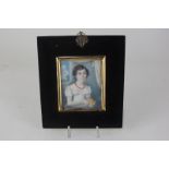 A 19th century portrait miniature on ivory depicting a young lady with waved brown hair and blue