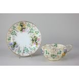 An early 19th century Coalport floral encrusted porcelain cup and saucer decorated in gilt with