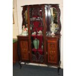 An Edwardian mahogany display cabinet with central panel glazed door enclosing three shelves flanked