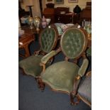 A near pair of Victorian upholstered fireside chairs with green button upholstered oval backs,