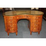 An Edwardian Sheraton style inlaid mahogany kidney shaped desk with leather inset top above an