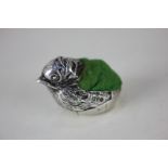 A George V silver pincushion modelled as a chick in an egg, maker Mordan & Co, Chester 1915