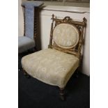A French style giltwood low chair with oval upholstered back panel, ribbon and fluted column