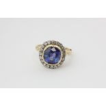 A sapphire and diamond cluster ring, the cushion cut stone within a border of eight cut diamonds