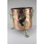 A studded copper and brass coal scuttle with two lion mask brass ring handles, decorated with