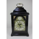 A George II ebonised bracket clock with 6 inch gilt metal break arch dial, marked John Everell,