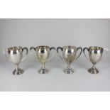 A set of three George V silver trophy cups on knopped stems and circular bases, each with