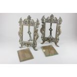A pair of brass photograph frames with ornately cast scrolled frames with masks and figures, on