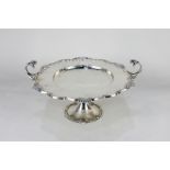 A George V silver tazza, circular top with scroll and shell border and two scroll handles mounted