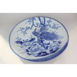 A Japanese porcelain blue and white charger depicting two storks flying over a tree with Mount