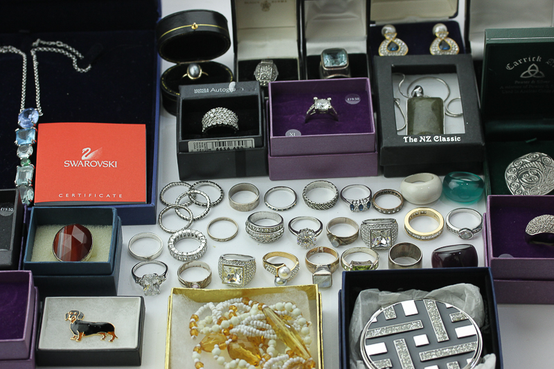 A large collection of costume jewellery rings, including some silver examples