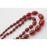 Two amber coloured bead necklaces, strung with graduated oval beads