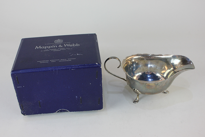 A Elizabeth II silver sauce boat with wavy border, scroll handle, on three hoof feet, maker Mappin &