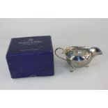 A Elizabeth II silver sauce boat with wavy border, scroll handle, on three hoof feet, maker Mappin &