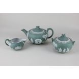 A Wedgwood green Jasperware tea set comprising teapot, sugar bowl and cover (a/f) and milk jug