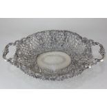 A Russian 84 zolotniks silver pierced oval dish with two scroll cast handles, pierced foliate and