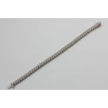 A diamond bracelet strung with quatrefoil links, each set with stones in 14ct white gold, stated