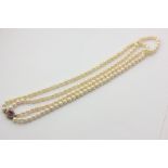 A two-row cultured pearl necklace, the uniform 7mm beads strung and knotted on a cabochon amethyst