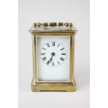 A brass carriage clock with white enamel dial and Roman numerals, 14cm high