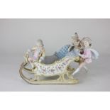 A Continental porcelain figure group of three children playing on a sleigh, 20cm high, (a/f)