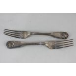 A pair of George IV silver fiddle pattern dinner forks with shell and thread terminals and