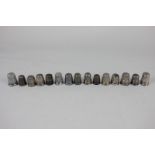 A collection of fourteen silver thimbles, various dates and makers, some a/f, with a plated thimble