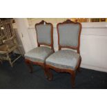 A pair of George I style dining chairs with cartouche shaped upholstered backs, sprung seats, on