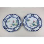 A pair of Chinese porcelain plates decorated with a central polychrome landscape inside a stylized