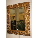 A gesso and giltwood wall mirror with scrolling foliate moulded frame, 62.5cm by 44cm