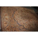 A large wool carpet with birds and scrolling floral design, in blue and orange on beige ground (a/
